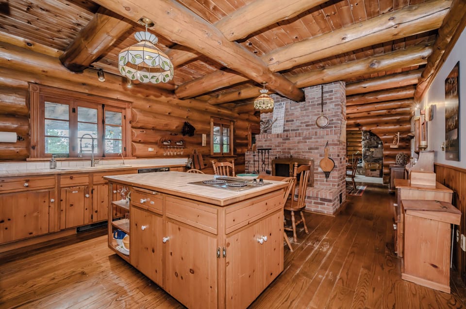 The kitchen flows seamlessly into the dining area, complete with a charming brick fireplace, offering the perfect blend of practicality and cozy sophistication.