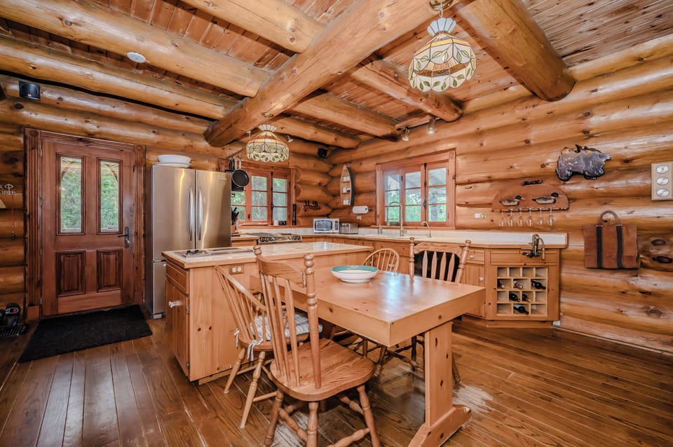 This inviting kitchen combines rustic charm with functionality, featuring natural wood finishes and a cozy dining nook for casual meals or morning coffee.