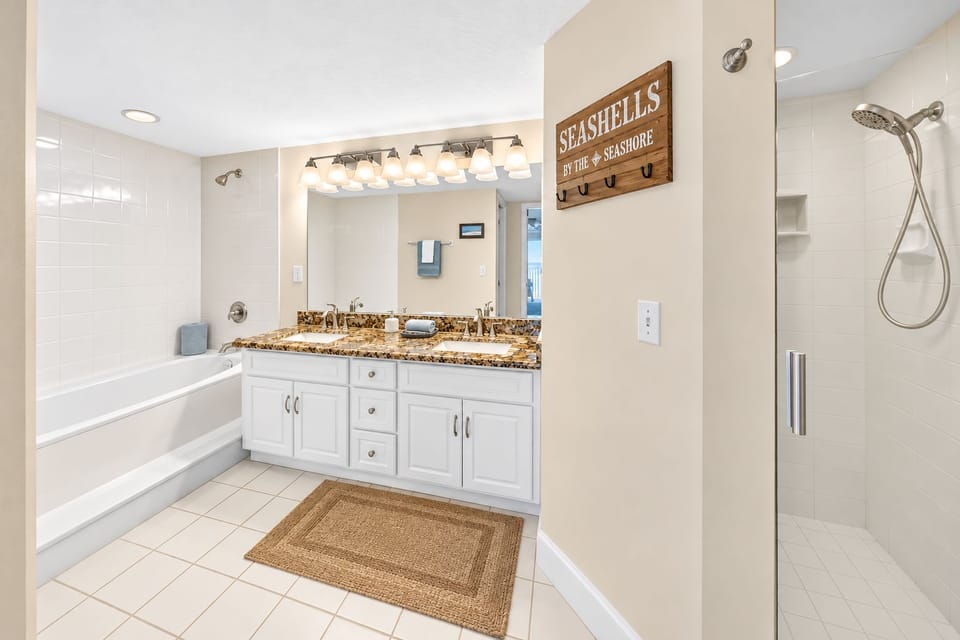 Your spacious bathroom features dual vanities with elegant granite counters, a soaking tub, and a separate walk-in shower—perfect for unwinding after beach adventures.
