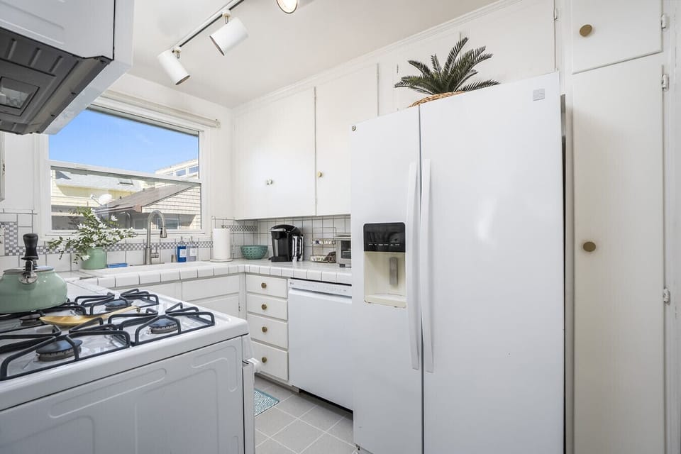 Fully equipped kitchen with complimentary coffee, tea, creamer, spices, and cleaning supplies
