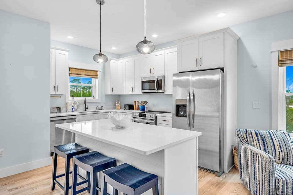 Enjoy cooking in your bright, modern kitchen with gleaming quartz countertops, stainless steel appliances, and coastal blue accents throughout.