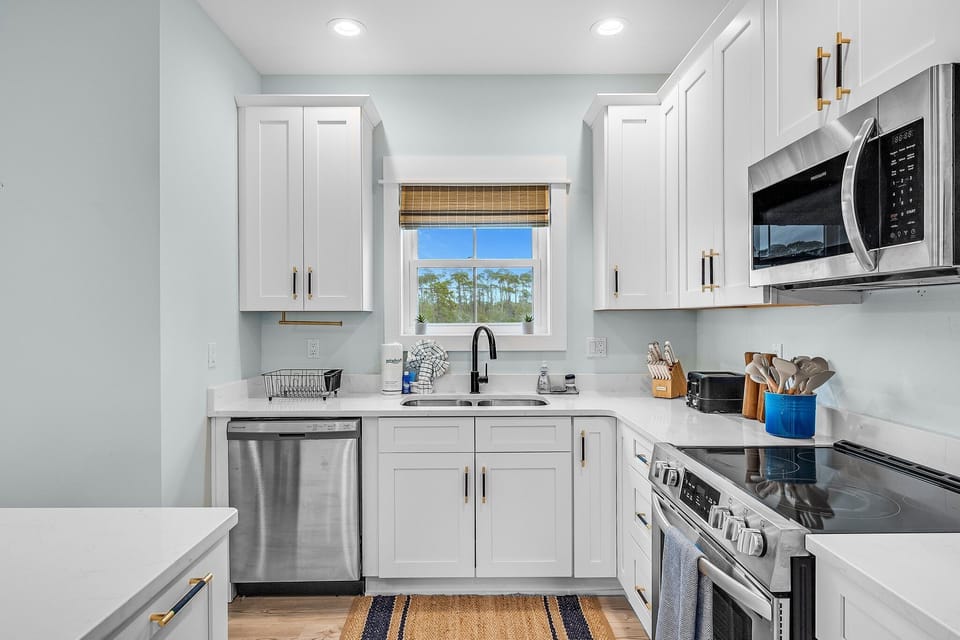 Your fully equipped kitchen features modern appliances and elegant white cabinetry, perfect for preparing memorable meals during your stay.