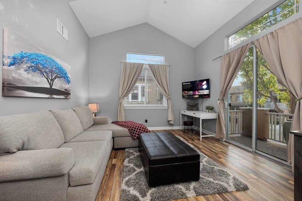 Cozy living room featuring comfortable couches, a TV for entertainment, and large windows that fill the space with natural light.