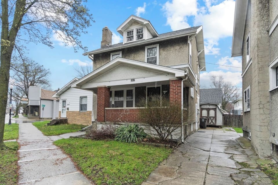 Stunning exterior of the house showcasing a beautiful front design, lush greenery surrounding the area, and a people-friendly walkway—creating a welcoming, vibrant atmosphere that blends modern style with natural beauty