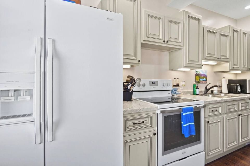 Spacious kitchen featuring a fridge and modern appliances, providing convenience and efficiency for all your cooking needs.