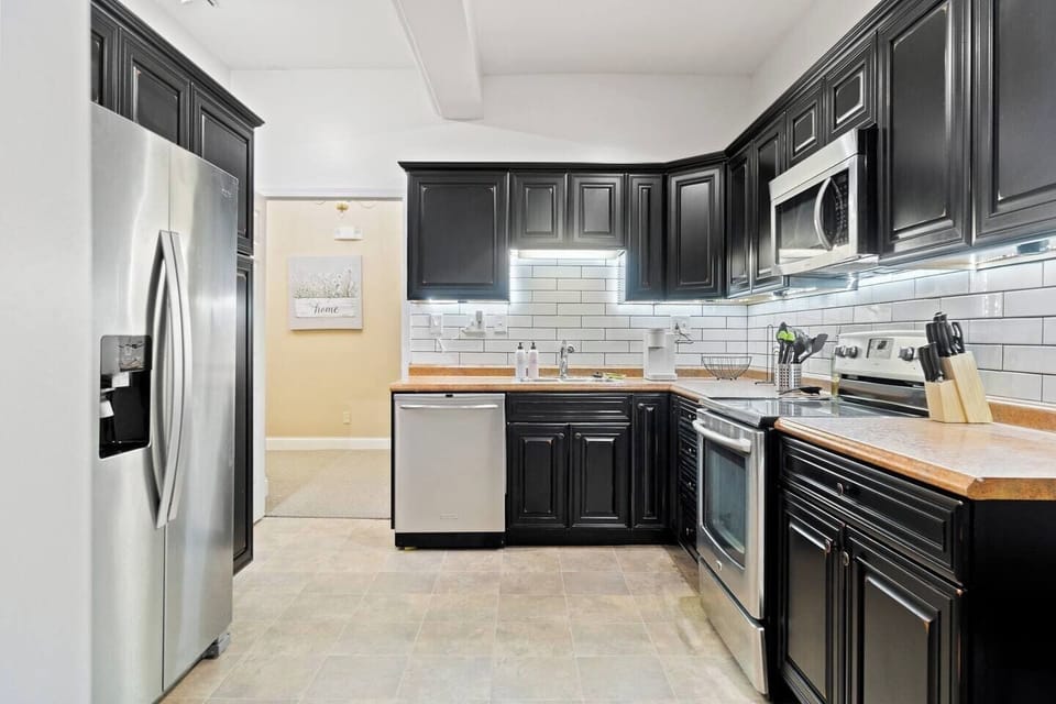 Fully equipped with modern kitchen appliances, including a sleek refrigerator, stove, and microwave, for a convenient and enjoyable cooking experience.