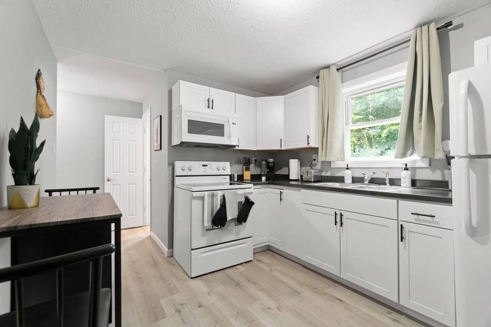 Fully equipped kitchen with modern appliances, complemented by a cozy dining area for two, perfect for meals at home.