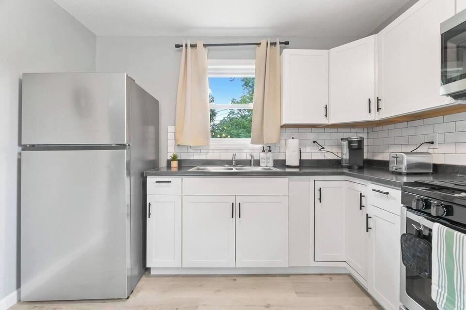 Well-equipped kitchen featuring a fridge, Keurig, toaster, stove with oven, and a variety of kitchenware for all your cooking needs.