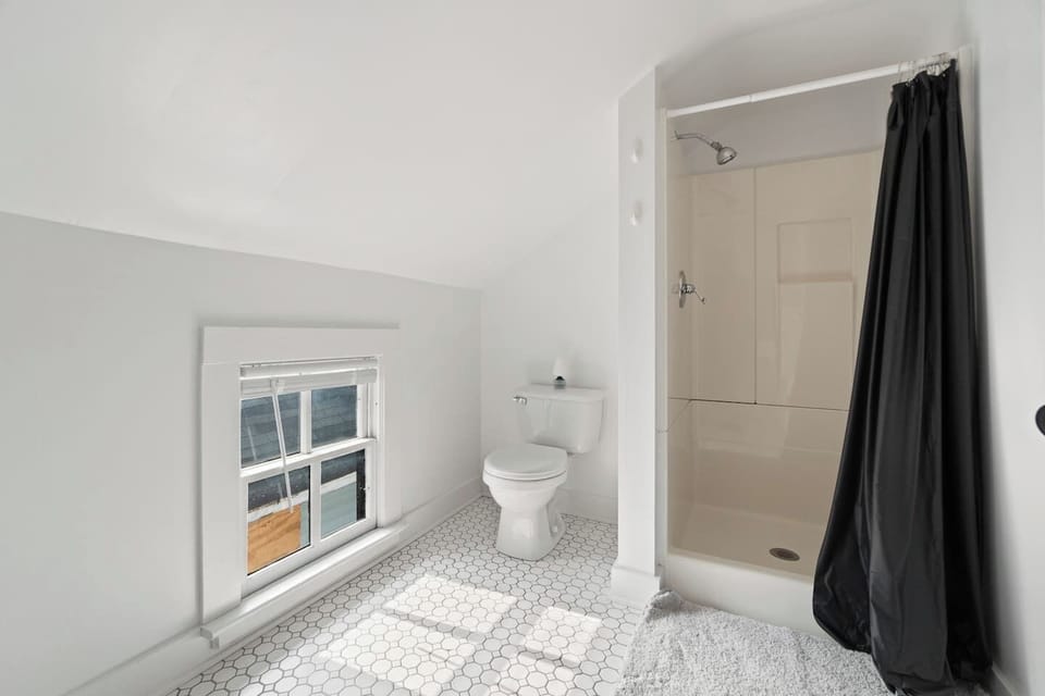 Modern bathroom featuring a spacious shower and a window that fills the space with natural light, creating a refreshing and inviting atmosphere.