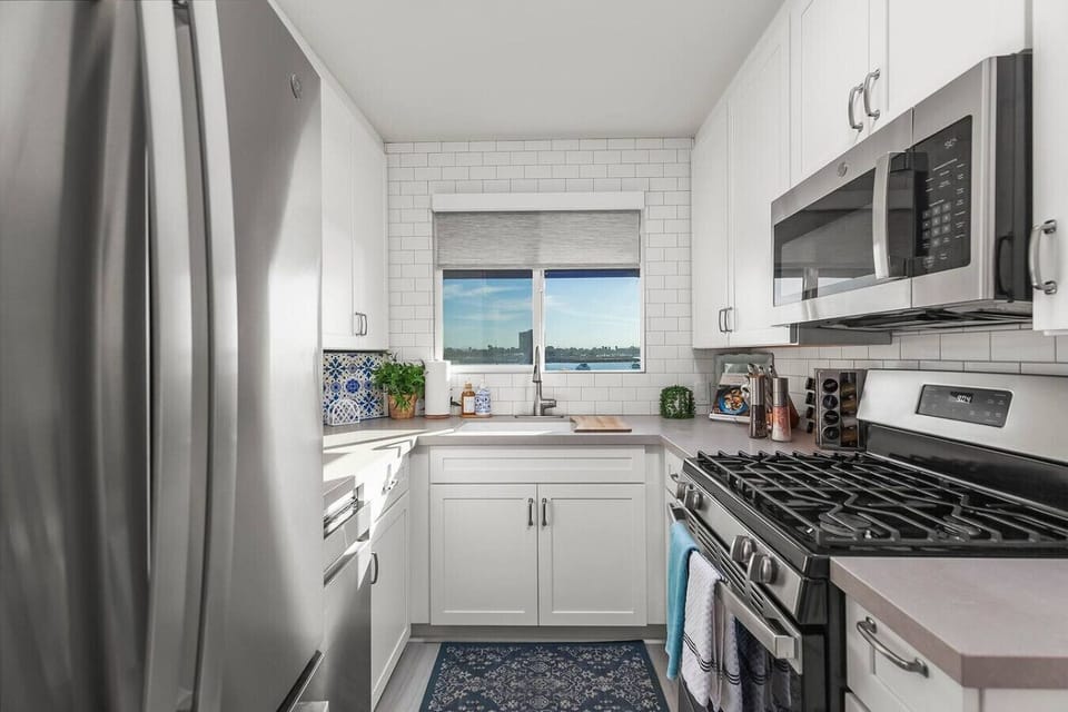 Fully stocked kitchen including Keurig machine, complimentary k-cups, creamers, spices, and a view.