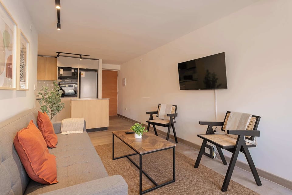 Cozy living room with modern decor and open kitchen, perfect for relaxing after a day of exploring.