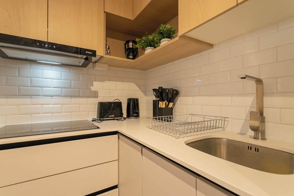 Sleek and modern kitchen with all the essentials for a perfect culinary experience, featuring stylish wooden cabinets and a chic subway tile backsplash.