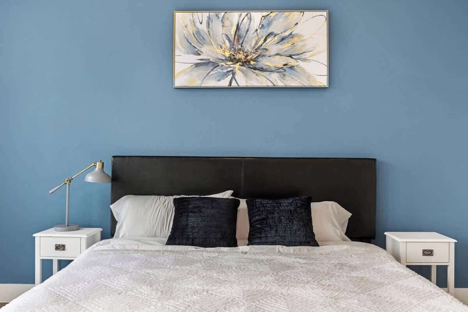 Bright bedroom w/ cozy bedding and a calm, uncluttered feel.