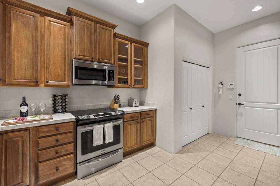 Kitchen area with stainless steel appliances with wood cabinets