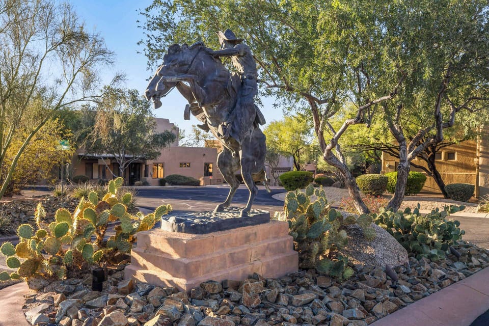 Charming desert landscape featuring a striking cowboy sculpture surrounded by cacti