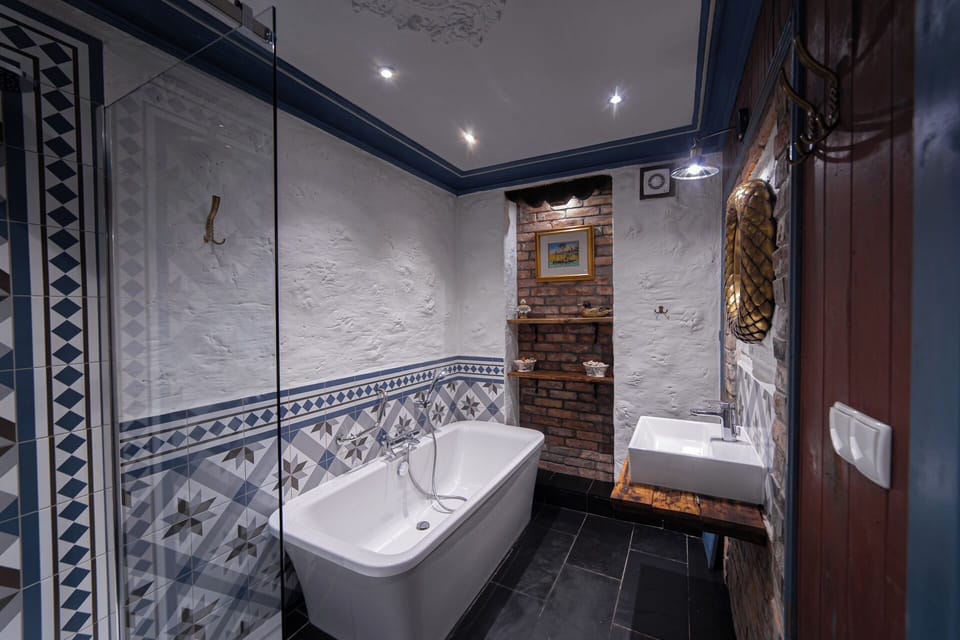 Deluxe Suite, 1 Queen Bed, Private Bathroom, Ground Floor | Bathroom | Hair dryer, slippers, towels, soap