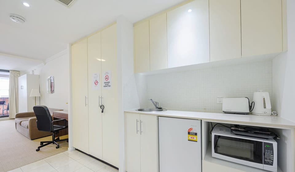 Kitchenette area featuring built-in cabinetry, bar fridge, microwave, kettle, and toaster.