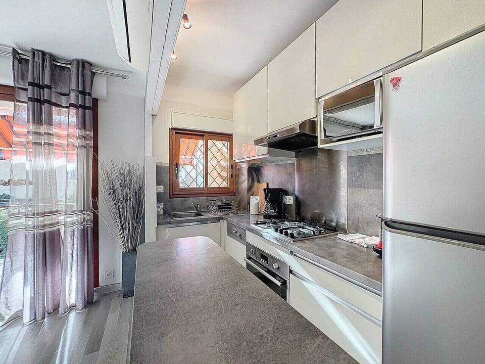 Imaginez préparer un repas en profitant de la lumière naturelle qui entre par la fenêtre tout en écoutant de la musique douce. La cuisine compacte est optimisée avec des appareils modernes pour une utilisation quotidienne pratique.