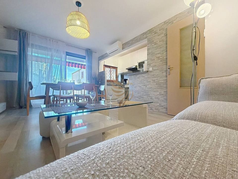 Salon chaleureux avec espace détente et coin repas, parfait pour se retrouver après une journée ensoleillée.