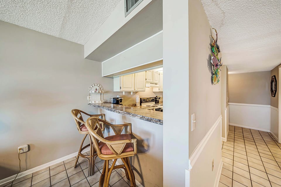 There is a dining table, perfect for enjoying a meal or playing a game, as well as additional breakfast bar seating.