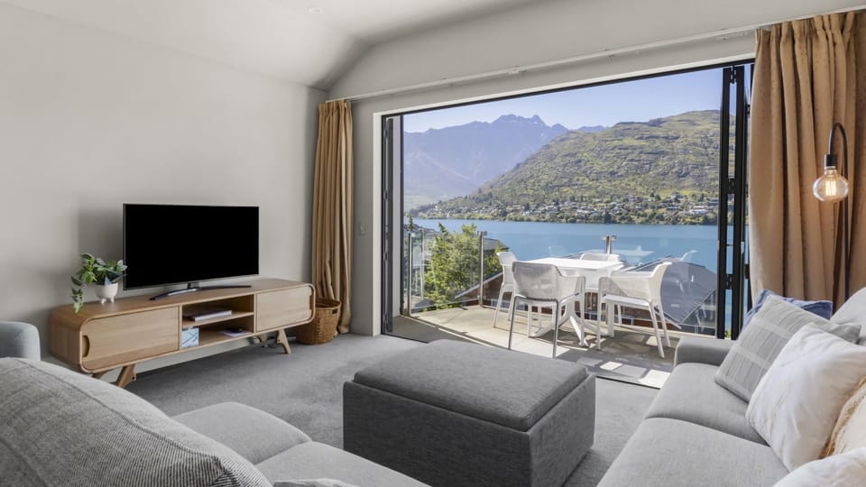 Living room with balcony and lake and mountain views