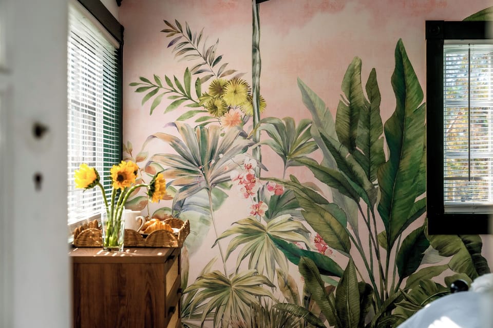 A stunning botanical retreat with a vibrant green bed frame and leafy wall mural for a touch of nature.