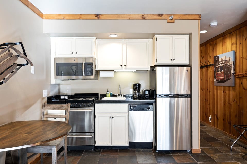 Bright kitchen with stainless steel appliances and slate floors—enjoy easy in-home dining during your Park City getaway.