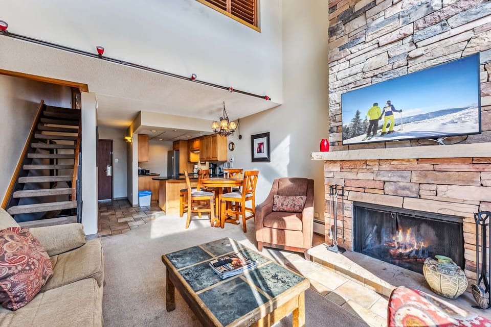 Living Room: Couch with pull-out bed, 2 lounge chairs, 50” Smart TV with cable, wood-burning fireplace, large windows, views of ski slopes