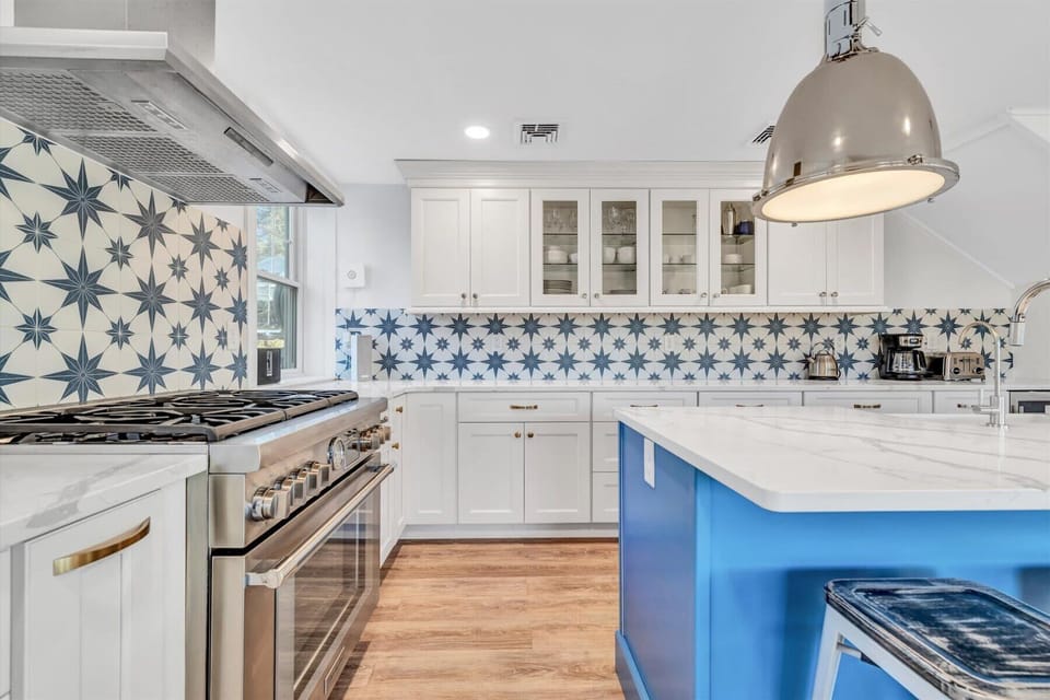 Fully equipped kitchen featuring high-end appliances, ample storage, and a vibrant backsplash.