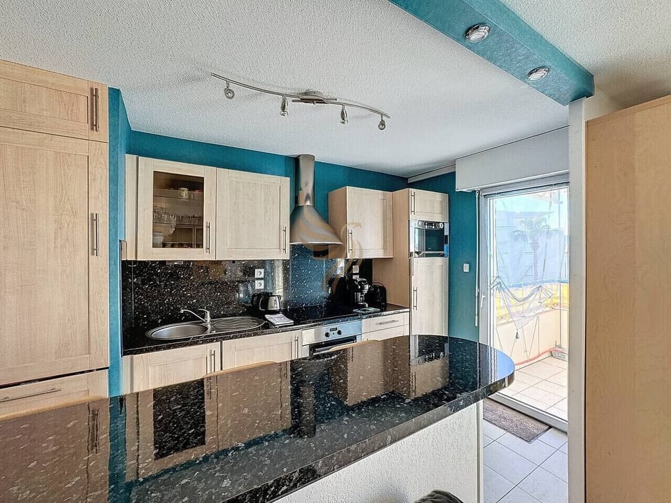 La cuisine dispose d`un bar invitant pour des petits-déjeuners conviviaux. La terrasse attenante offre un espace idéal pour profiter du soleil, parfait pour des repas en plein air ou une pause café avec vue.