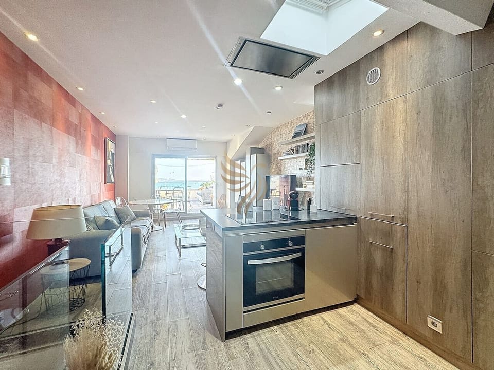 logement moderne, baigné de lumière grâce à sa grande baie vitrée, propose un espace convivial. L`îlot de cuisine est idéal pour la préparation de repas en famille ou entre amis. Imaginez-vous ici, savourant un café matinal avec vue sur la mer.