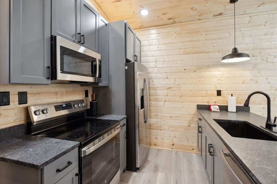 Kitchen: Sleek gray cabinetry and modern appliances set the stage for culinary adventures!