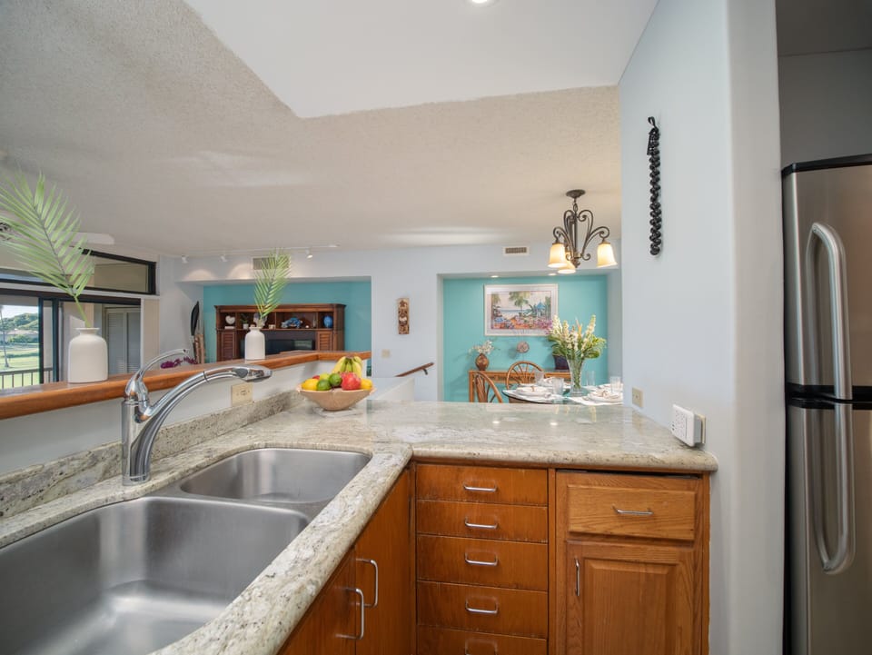 Fully equipped kitchen featuring sleek appliances, granite countertops, and a breakfast bar. Ideal for preparing meals after exploring the nearby beach.