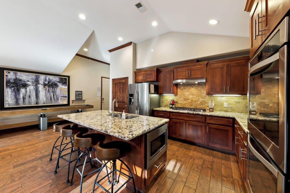Your gourmet kitchen awaits with granite counters, rich wood cabinets, and stainless appliances perfect for creating memorable meals together.