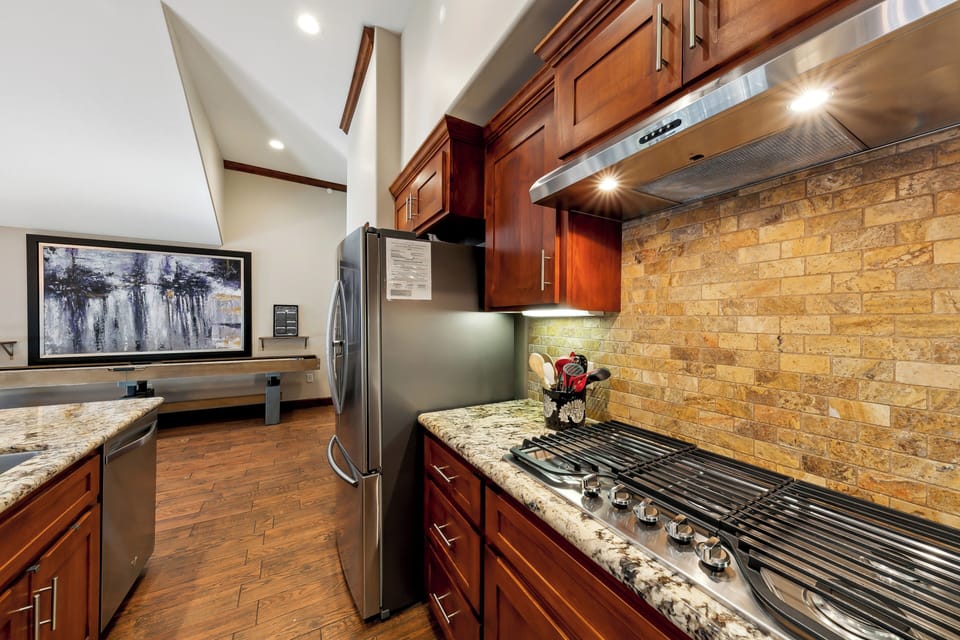 Your gourmet kitchen awaits with rich wood cabinets, granite counters, and professional-grade appliances for creating memorable meals.
