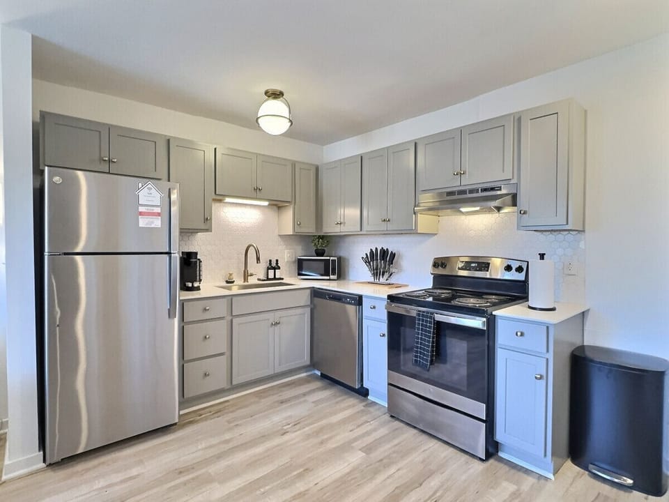 Modern kitchen with sleek stainless steel appliances and neatly arranged utensils, perfect for effortless cooking during your short-term rental stay.