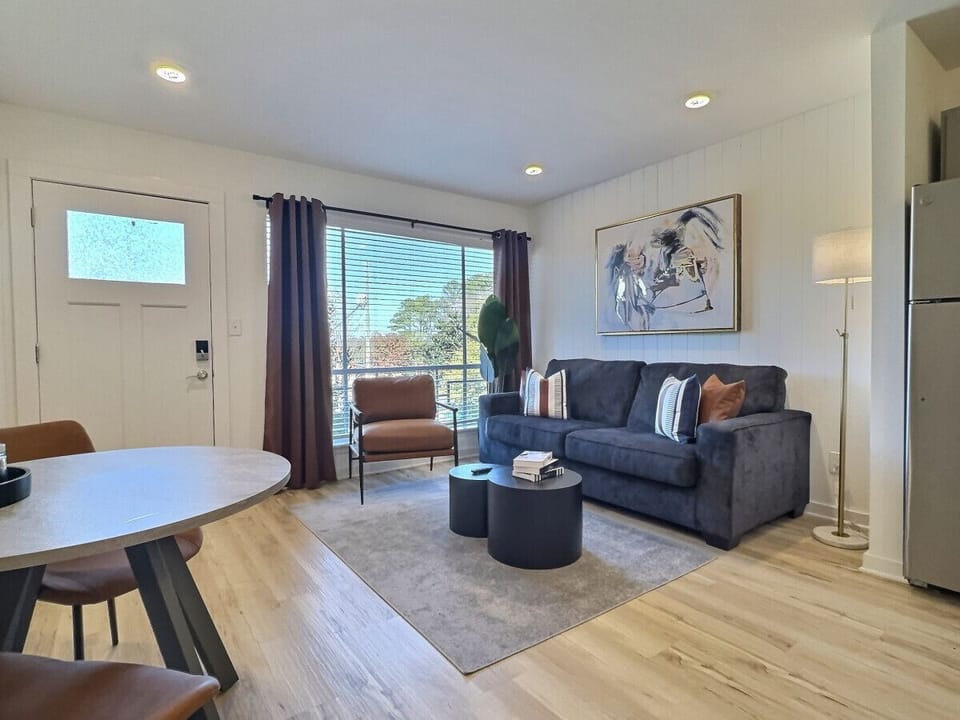 An elegant living area in Downtown Birmingham that blends modern design, natural light, and cozy touches for the perfect stay.