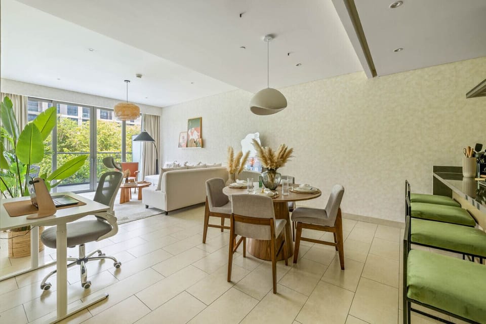 Open-plan space with a dining table, work desk, and living room with large windows