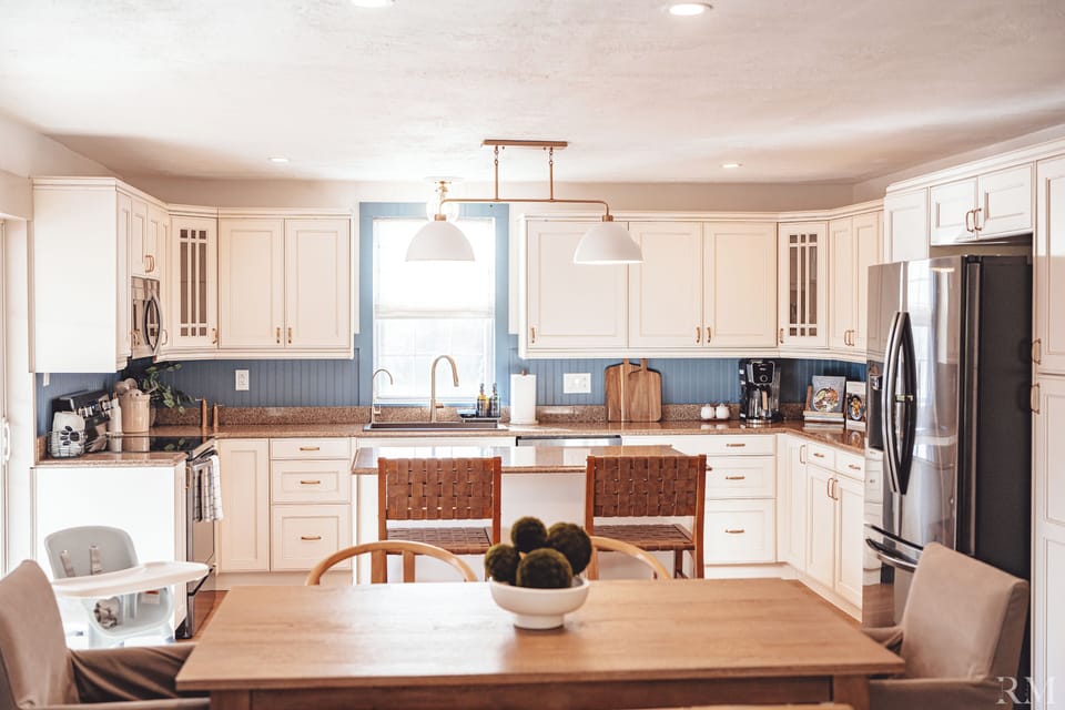 A modern dining space for 6 and kitchen with an island offering 2 counter seats.