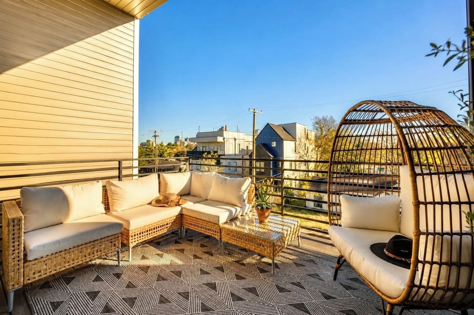 Sunny private balcony with stylish lounge seating and cozy egg chair.