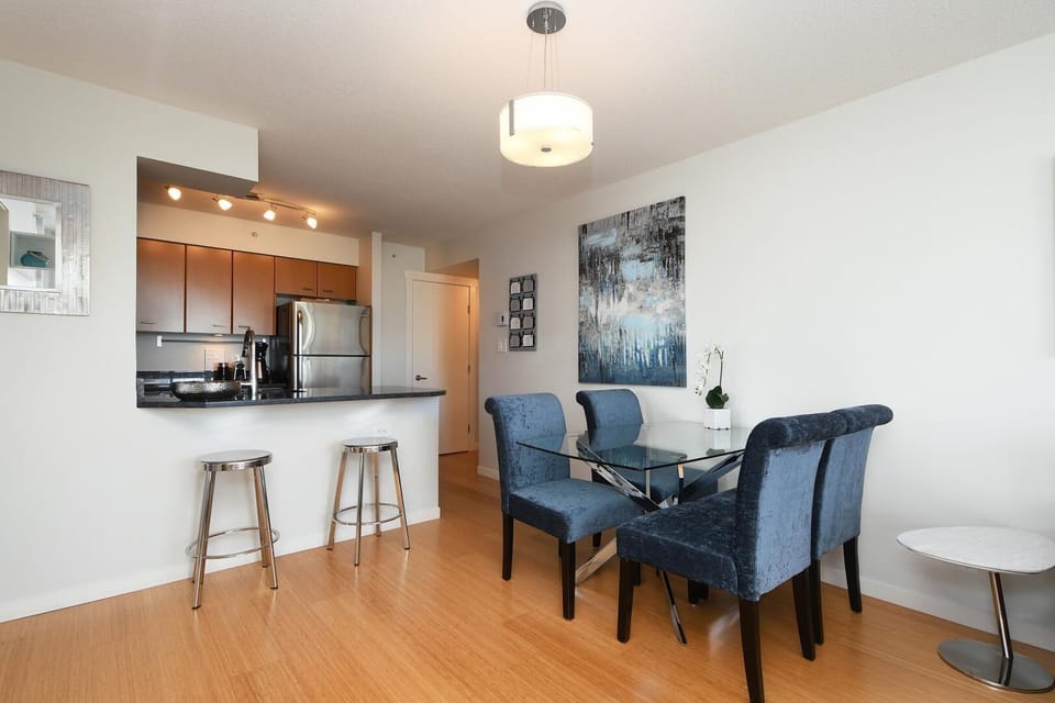 Open-concept living and dining area featuring warm hardwood floors and a seamless layout.
