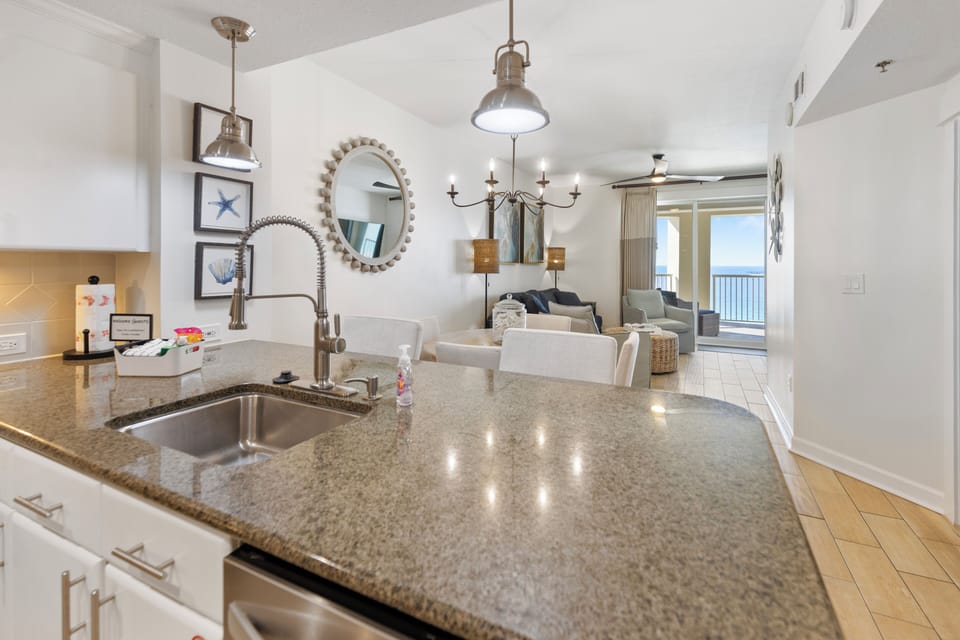 Your modern kitchen features granite counters and opens beautifully to a bright living area with stunning ocean views through floor-to-ceiling windows.