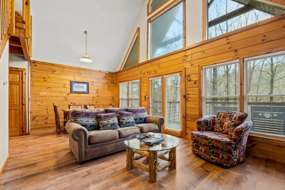 Open floorplan living room with high ceilings and large windows that let in lots of natural light.