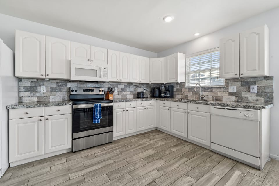 Fully stocked kitchen with all essential appliances and utensils.