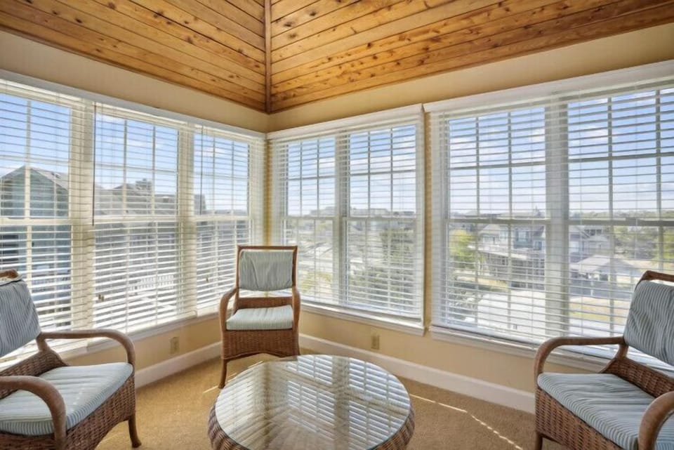 Settle into a sunlit space where natural wood warmth meets sweeping neighborhood vistas—your perfect retreat for morning coffee or quiet reflection.