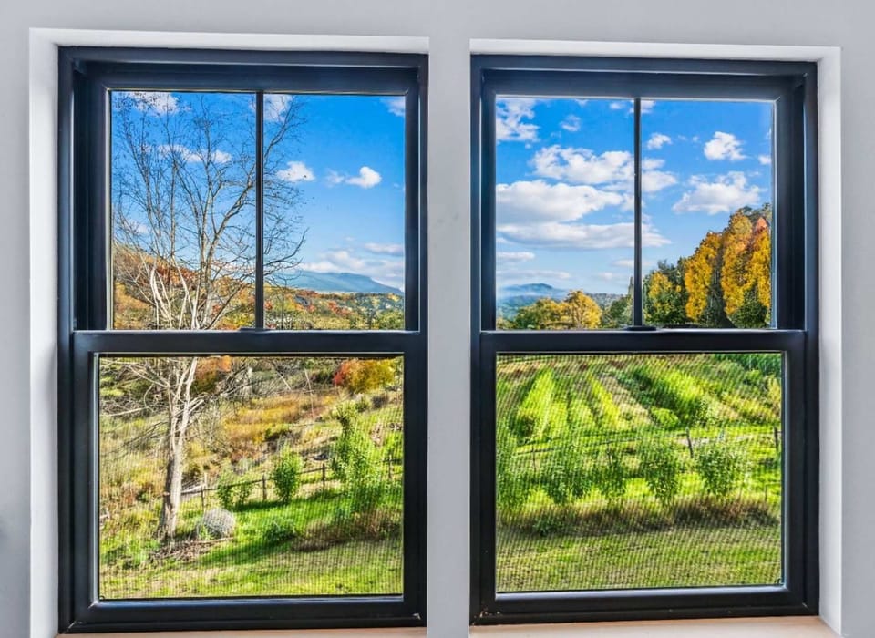Floor-to-ceiling windows framing the Vermont countryside