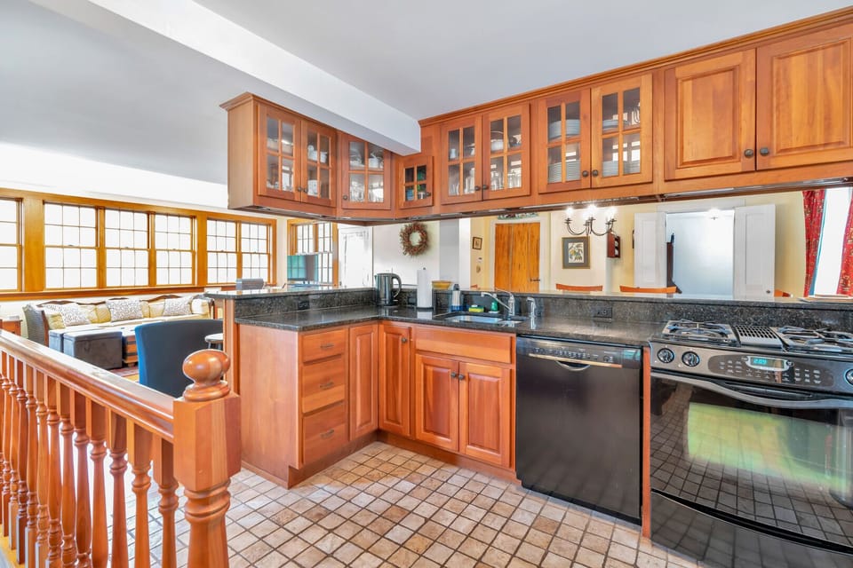 Fully equipped kitchen with cherry cabinets, granite counters, and tile floor
