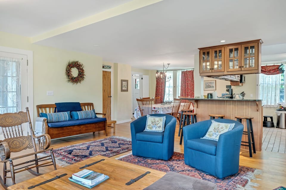 Open living area with blue armchairs, rocking chair, and wide-plank hardwood floors