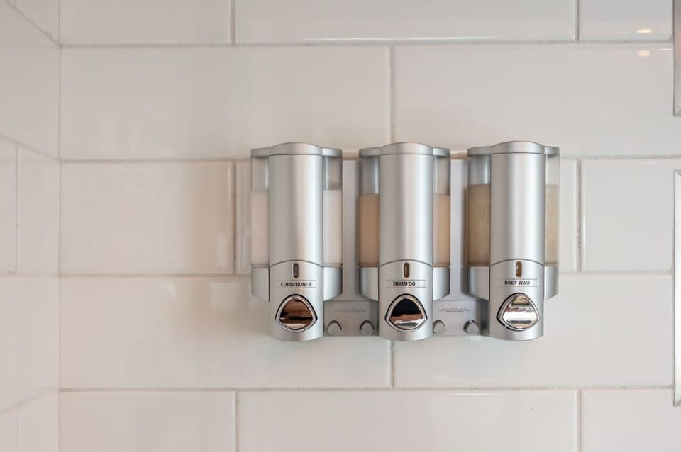 Wall-mounted dispensers add a clean, modern touch to the bath area.
