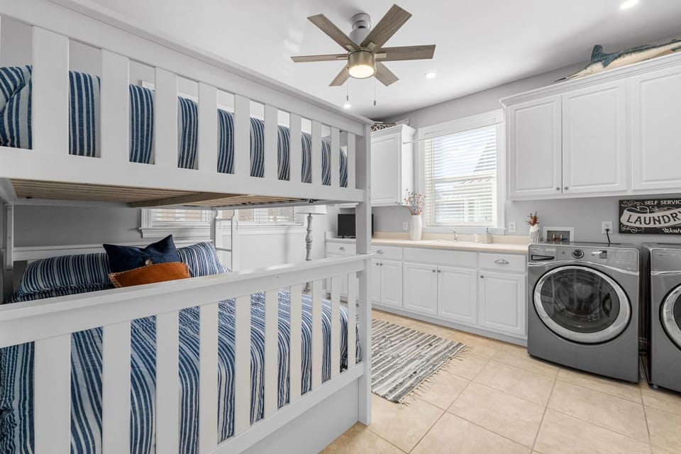 A versatile space featuring a Full bunk bed alongside a convenient laundry setup with modern appliances, blending comfort and functionality.